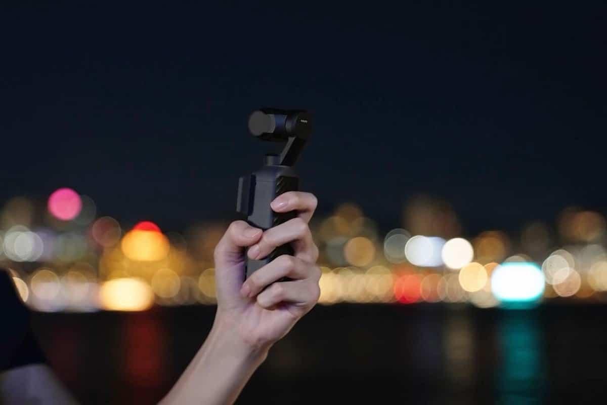 Cầm DJI Osmo Pocket 4 quay ban đêm trước phố đèn bokeh