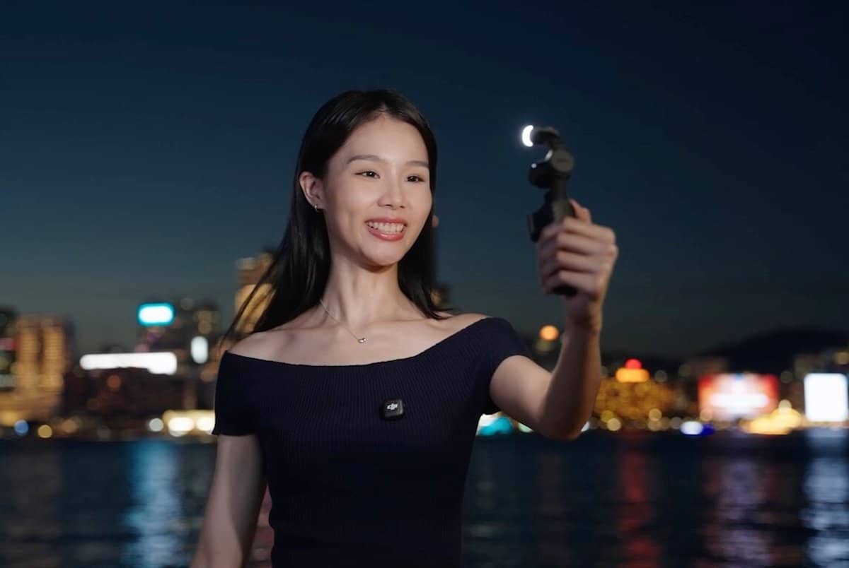 Cô gái quay vlog phố đêm bằng DJI Osmo Pocket 4 bên bờ sông lên đèn